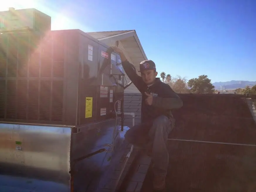 HVAC technician performing HVAC Inspection on a rooftop unit in Maitland